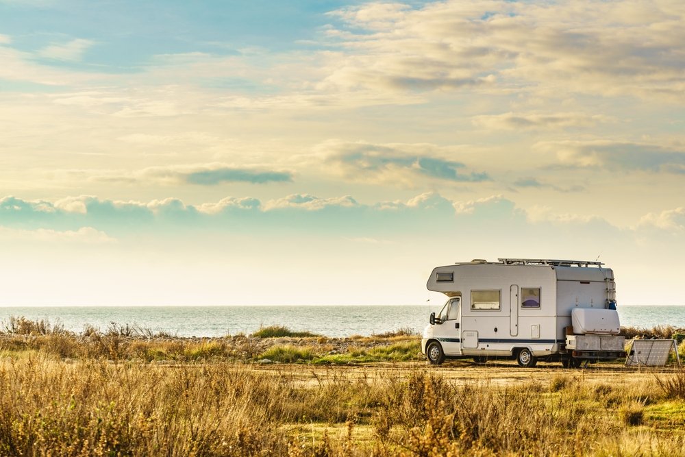 Camper vehicle camping on nature seacoast. Adventure, tour with mobile home.